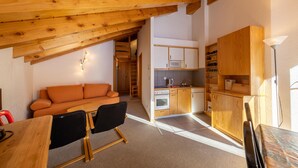 A compact kitchen with wooden cabinets, a microwave, and a stove.