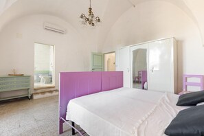 Ein Schlafzimmer mit Bett, Kleiderschrank, Schminktisch und angrenzendem Badezimmer.