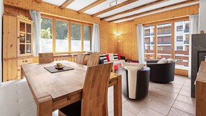 A wooden interior with a dining table, chairs, a sofa, and a fireplace. - Le Torrent 26 - 6 pers - au calme (Haute-Nendaz)