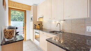 A modern kitchen with light wood cabinets, a granite countertop, and a built-in oven. - Le Torrent 26 - 6 pers - au calme (Haute-Nendaz)