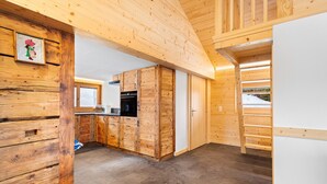 A modern kitchen with wooden cabinetry and a view of the outdoors.