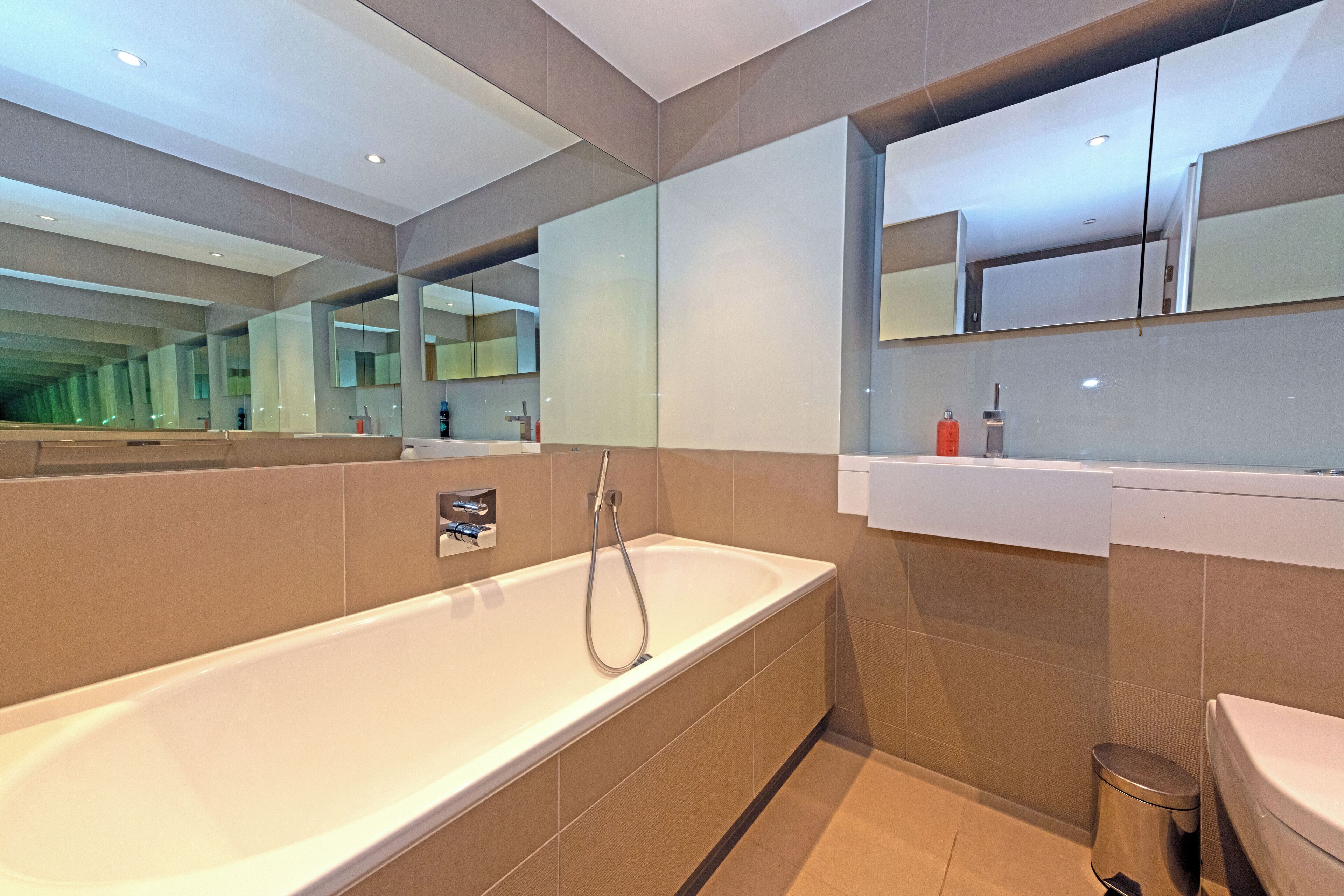 Ein modernes Badezimmer mit einer großen Badewanne, einer Toilette und einem Waschbecken.