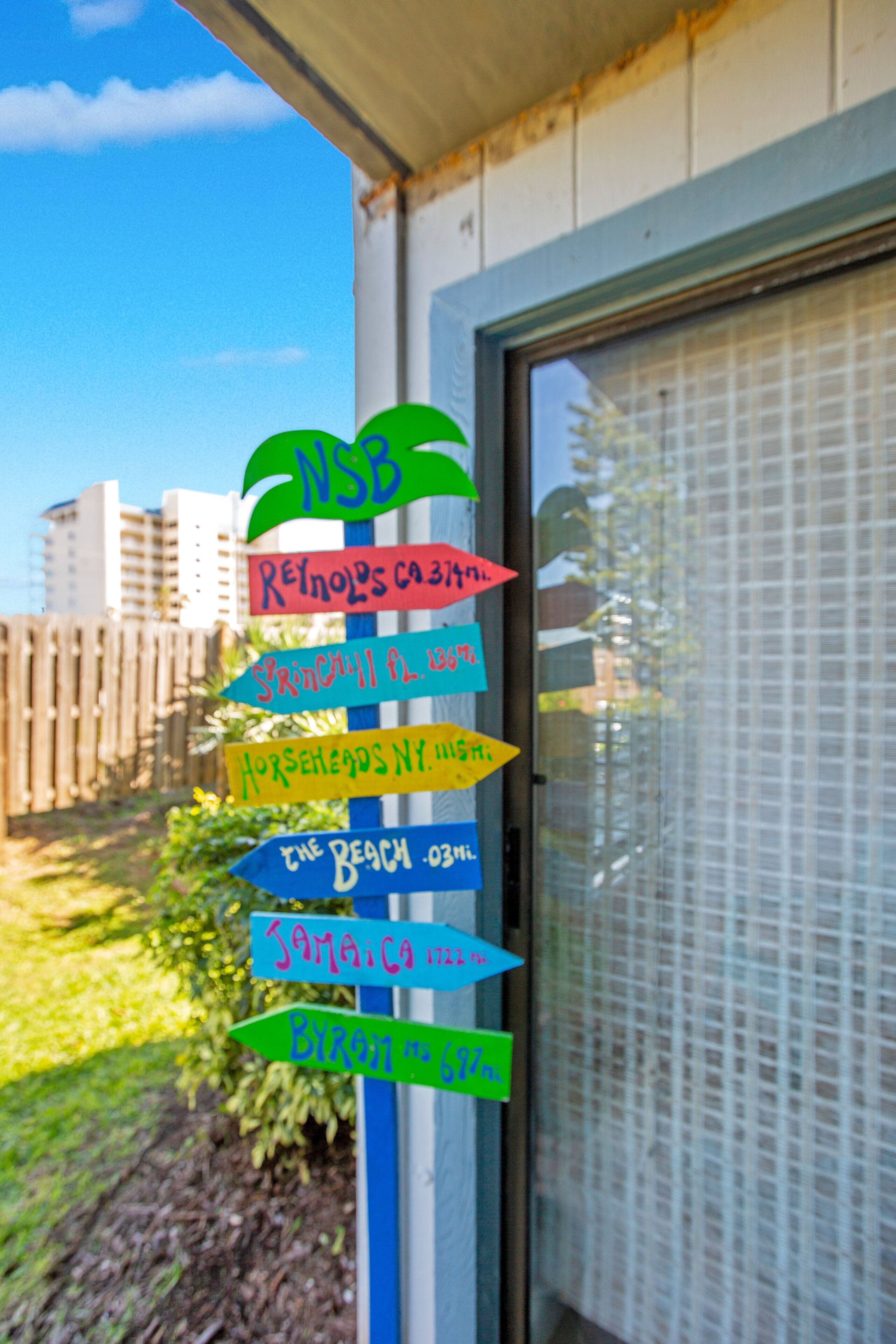 A colorful directional sign with multiple arrows pointing to various destinations.
