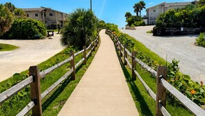 A pathway leading to a building with a wooden fence on both sides.