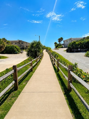 A pathway leading to a building with a wooden fence on both sides. - Soak in the Sun in New Smyrna Beach ★ Family Friendly Retreat ★ Short Walk (New Smyrna Beach)