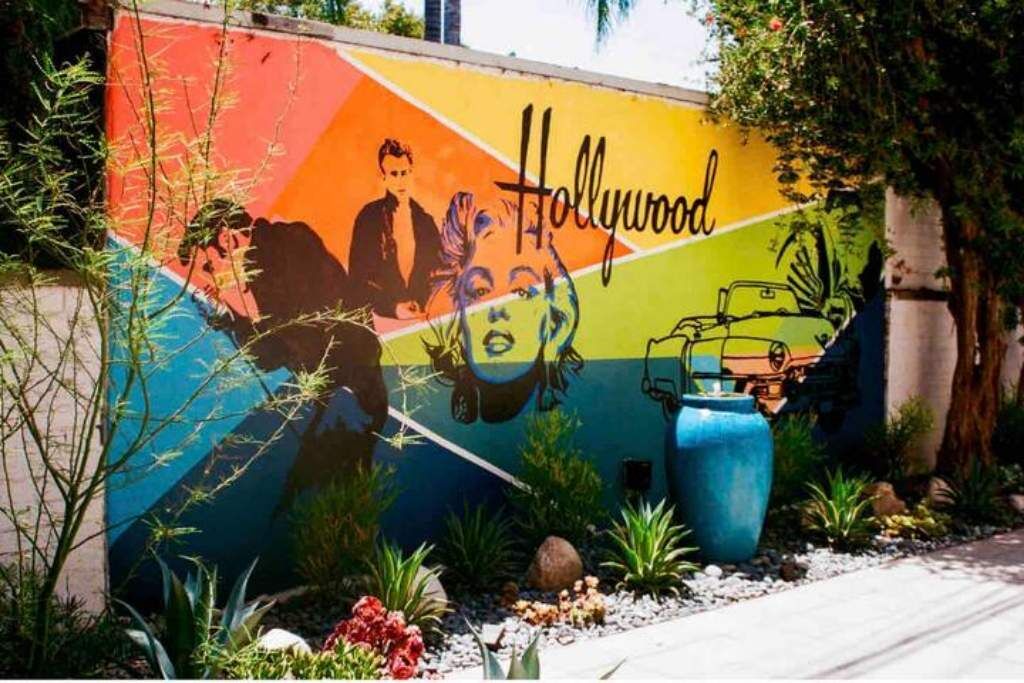 Un mural colorido con la palabra "Hollywood" y siluetas de personas y un coche.