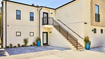 A two-story building with a central staircase, a small balcony, and a door.