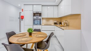 A modern kitchen with white cabinets, a built-in oven, and a sink. - Sublime and Bright 2 BDR Apartment by LovelyStay (Quarteira)