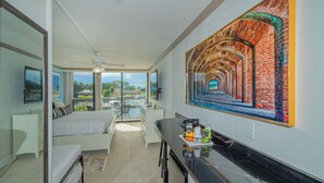 A hotel room with a balcony, a bed, a desk, and a large mural of a brick archway. - ALL-NEW Waterfront with Balcony, Pool, Tiki Bar, Gym (Sarasota)