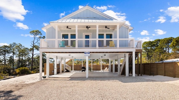 A two-story house with a covered front porch, multiple balconies, and a sign indicating 'Blue Sea Star'. - Poolside Getaway Near the Beach (Port Saint Joe)