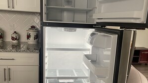 An open refrigerator with a clear interior, a control panel, and a small basket on top. - COZY SUITE DREAM HOME IN BLOOMFIELD  (Bloomfield)