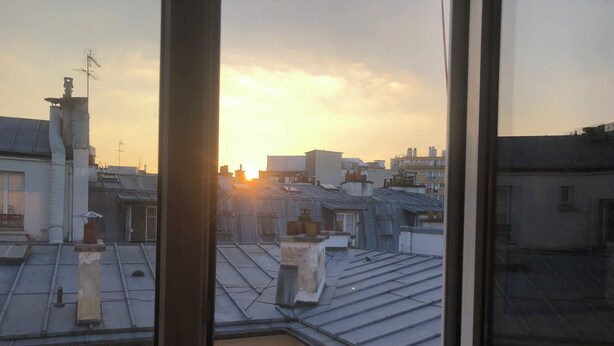 A view of rooftops with buildings and chimneys, taken from inside a building looking out through a window. - Vue sur les Toits de Paris ! Calme , Lumineux ! Deux Pièces Refait à Neuf ! (Paris)