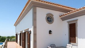 A building with a tiled roof, a pool, and a patio with a table and chairs. - Gyrus Villa, São Brás de Alportel, Algarve, Piscina Pool, Wifi (São Brás de Alportel)