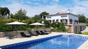 A swimming pool with lounge chairs and umbrellas, a white building with a red roof, and trees in the background. - Gyrus Villa, São Brás de Alportel, Algarve, Piscina Pool, Wifi (São Brás de Alportel)