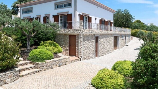 A two-story house with a stone facade, a balcony, and a paved driveway. - Gyrus Villa, São Brás de Alportel, Algarve, Piscina Pool, Wifi (São Brás de Alportel)