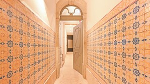 A hallway with patterned tile walls and a carpeted floor. - FindMe inPorto Bonfim (Porto)