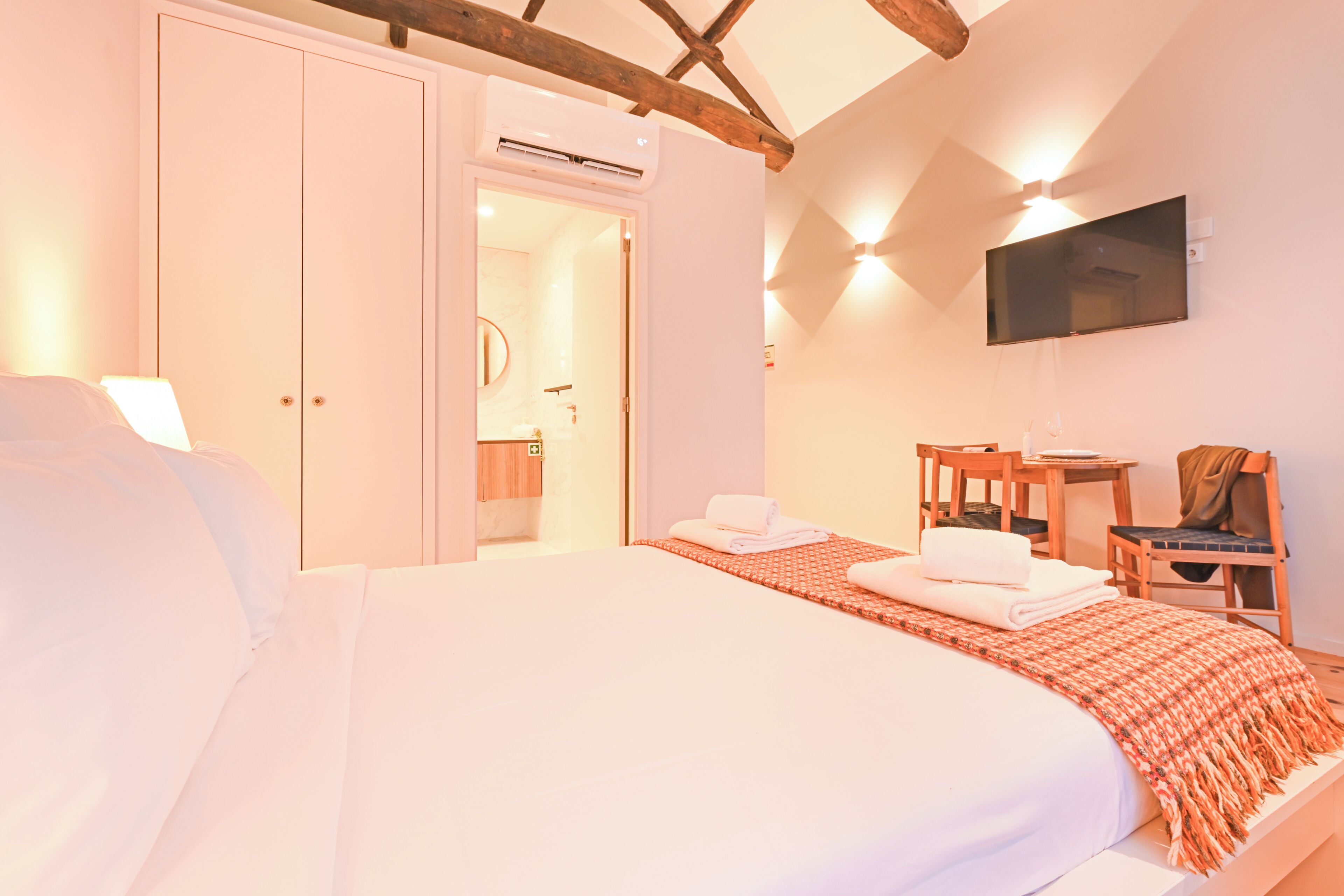 Une chambre à coucher comprenant un lit, un bureau, une chaise, une télévision et une armoire.