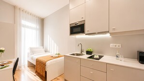 A modern kitchen with a microwave, sink, and cabinets. - FindMe inPorto Bonfim (Porto)
