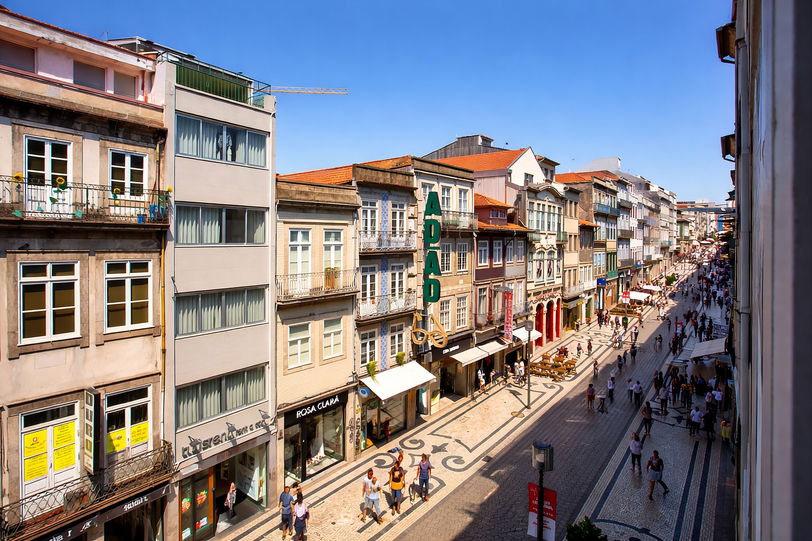 A street view of a city with multi-story buildings, shops, and pedestrians.