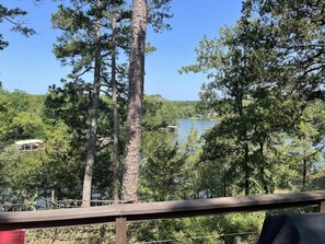 A view of a lake surrounded by tall trees and a wooden deck. - The Juniper ~ Cabin Fourteen ~ Pet Friendly ~ Lakefront (Royal)