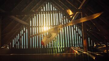 A model airplane in a wooden structure with a sloped roof.