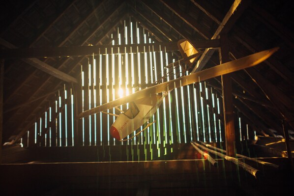 A model airplane in a wooden structure with a sloped roof.