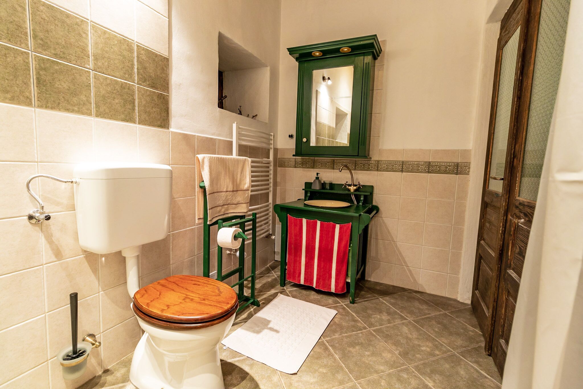 A bathroom with a toilet, sink, and mirror.