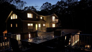 A two-story house with a balcony and a deck, featuring multiple windows and a staircase. - Four Seasons For Fun (Lakeville)