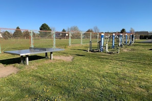 A playground with exercise equipment and a table tennis table.