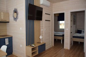 A room with a bed, a desk, a chair, a TV, and a wardrobe.