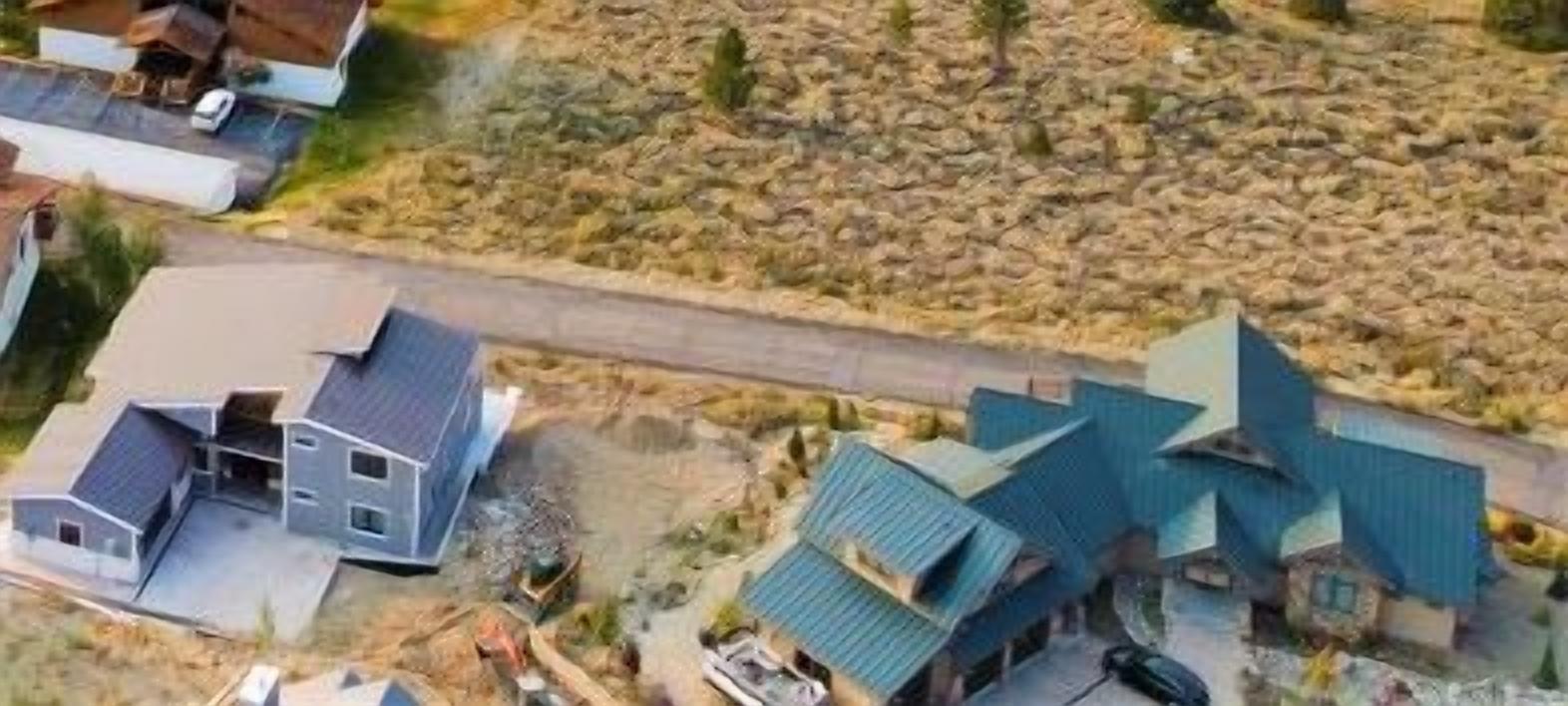 Un quartier résidentiel composé de plusieurs maisons, dont certaines sont en construction, avec un paysage rocheux en arrière-plan.