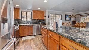 A modern kitchen with wooden cabinets, stainless steel appliances, and a granite countertop. - Large, renovated Interlaken condo that accommodates 10! (June Lake)