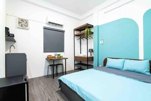 Relax in a clean and functional room with a comfortable bed, desk, and air conditioning unit.