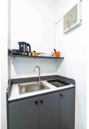 Functional kitchen with stainless steel sink, induction cooktop, and ample storage.
