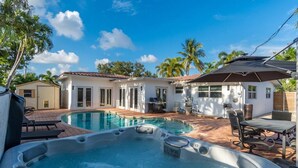 A backyard with a swimming pool, hot tub, patio furniture, and a covered seating area. - Modern Luxury, 2 Mi From Beach! (Fort Lauderdale)