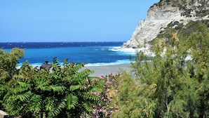 A coastal view with a rocky cliff and a beach.