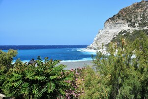 Vista costera con un acantilado rocoso y una playa.