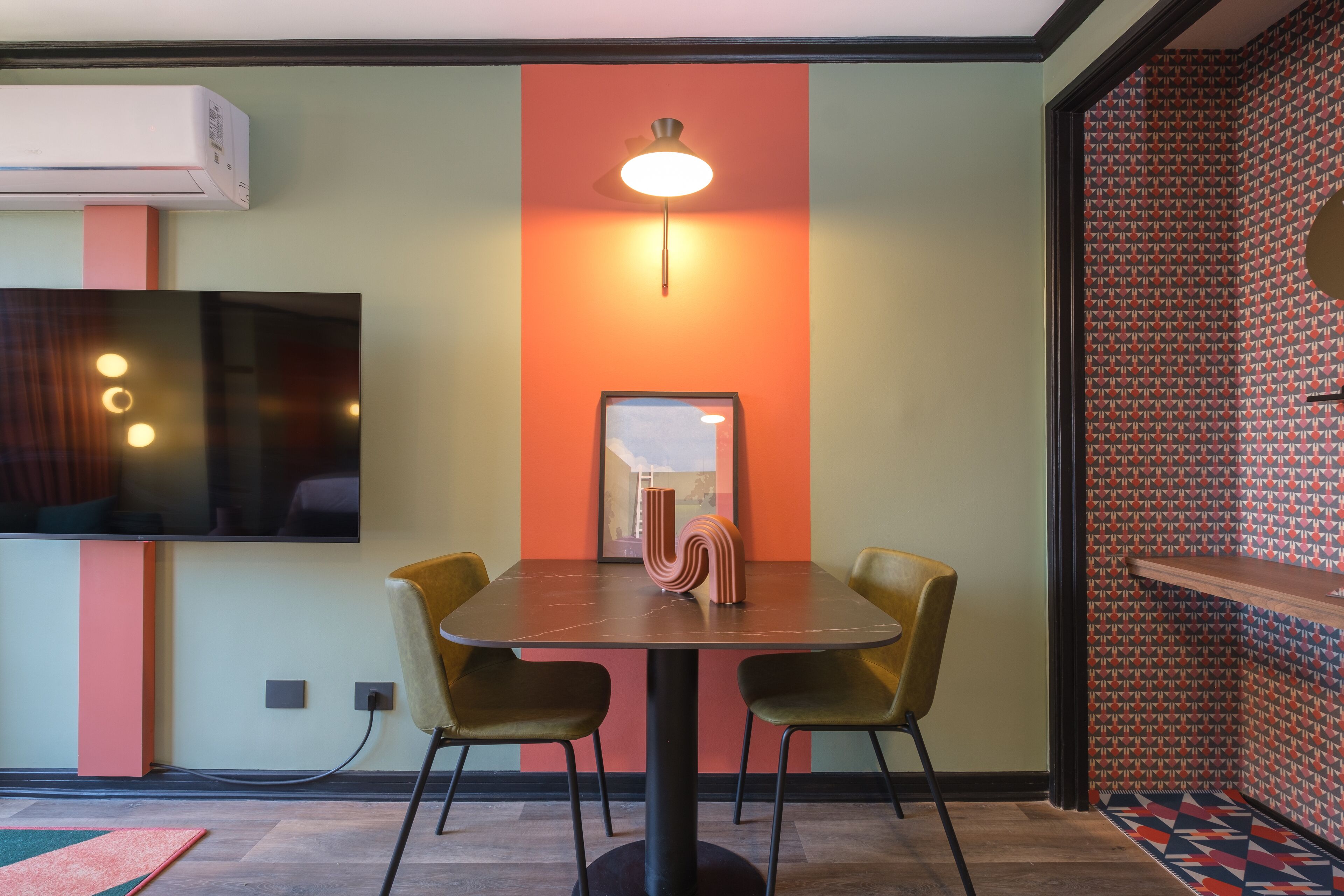 A modern dining area with a table, chairs, and a unique wall design.