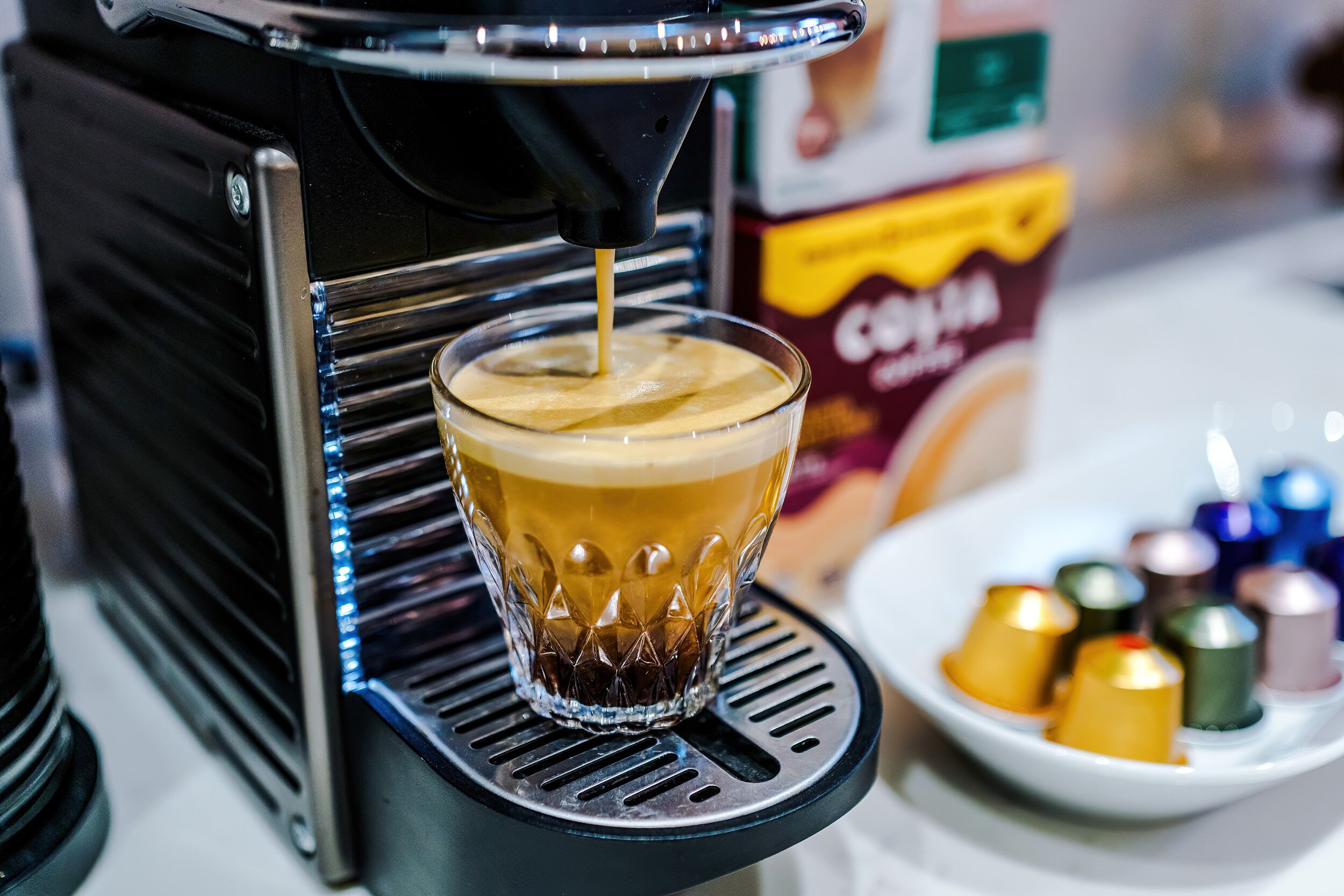 Eine Kaffeemaschine füllt Kaffee in ein Glas.