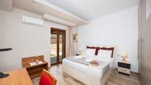 Une chambre à coucher comprenant un lit, des tables de chevet, un bureau et une chaise.
