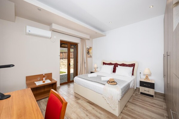 Un dormitorio con cama, mesitas de noche, un escritorio y una silla.