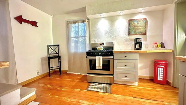 A compact kitchen with a stove, oven, and a small countertop. - 1890s Carriage House \ Walk To Downtown (Raton)