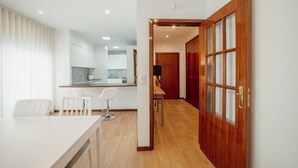 A modern kitchen with white cabinets and a wooden countertop. - City Center Grand SEA View Terrace by Vacationy (Porto)