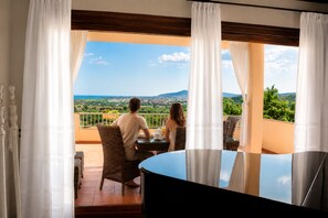 A couple dining at a table with a view of a landscape. - B&B Villa delle Rose (Budoni)