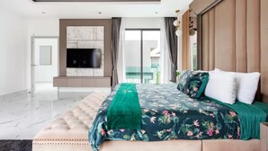 A modern bedroom with a large bed, a TV mounted on the wall, and a view of the outside. - Family-sized holiday house with private pool, perfect for families and friends! (Chonburi)