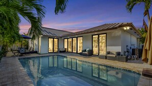 A modern house with a swimming pool, large windows, and outdoor seating. - Lynora's Luxe Estate Modern Design (Fort Lauderdale)
