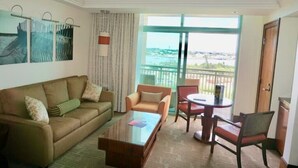 A hotel room with a sofa, armchairs, a coffee table, and a balcony with a view. - Gorgeous Studio The Reef Atlantis

 (Nassau)