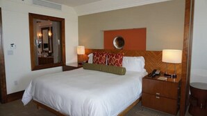 A hotel room with a large bed, two bedside tables, a mirror, and a wall-mounted clock. - Gorgeous Studio The Reef Atlantis

 (Nassau)