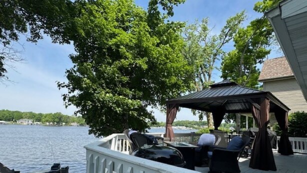 Une terrasse dotée de mobilier d’extérieur, d’un belvédère et offrant une vue sur l’eau.