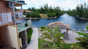 A hotel with a balcony, a pool, and a gazebo.